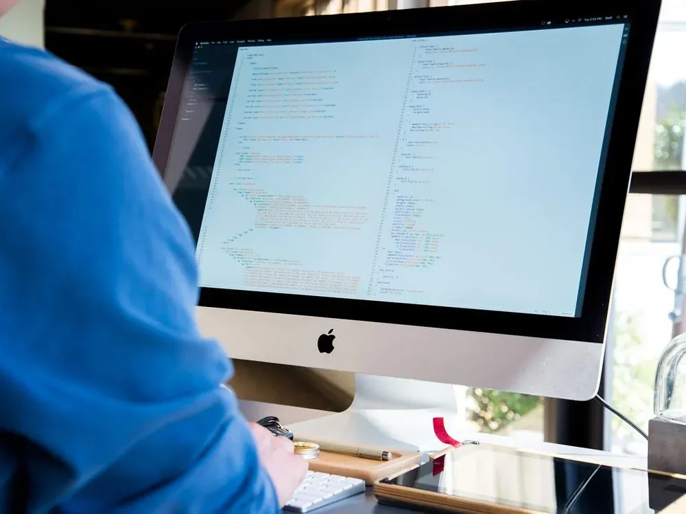 Développeur écrivant du code à son poste de travail — illustration : Devenir développeur Python