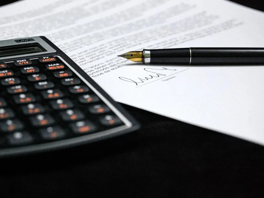 Un devis adapté aux sites de comptables et fiduciaires Calculatrice posée sur un document signé, sur un bureau.